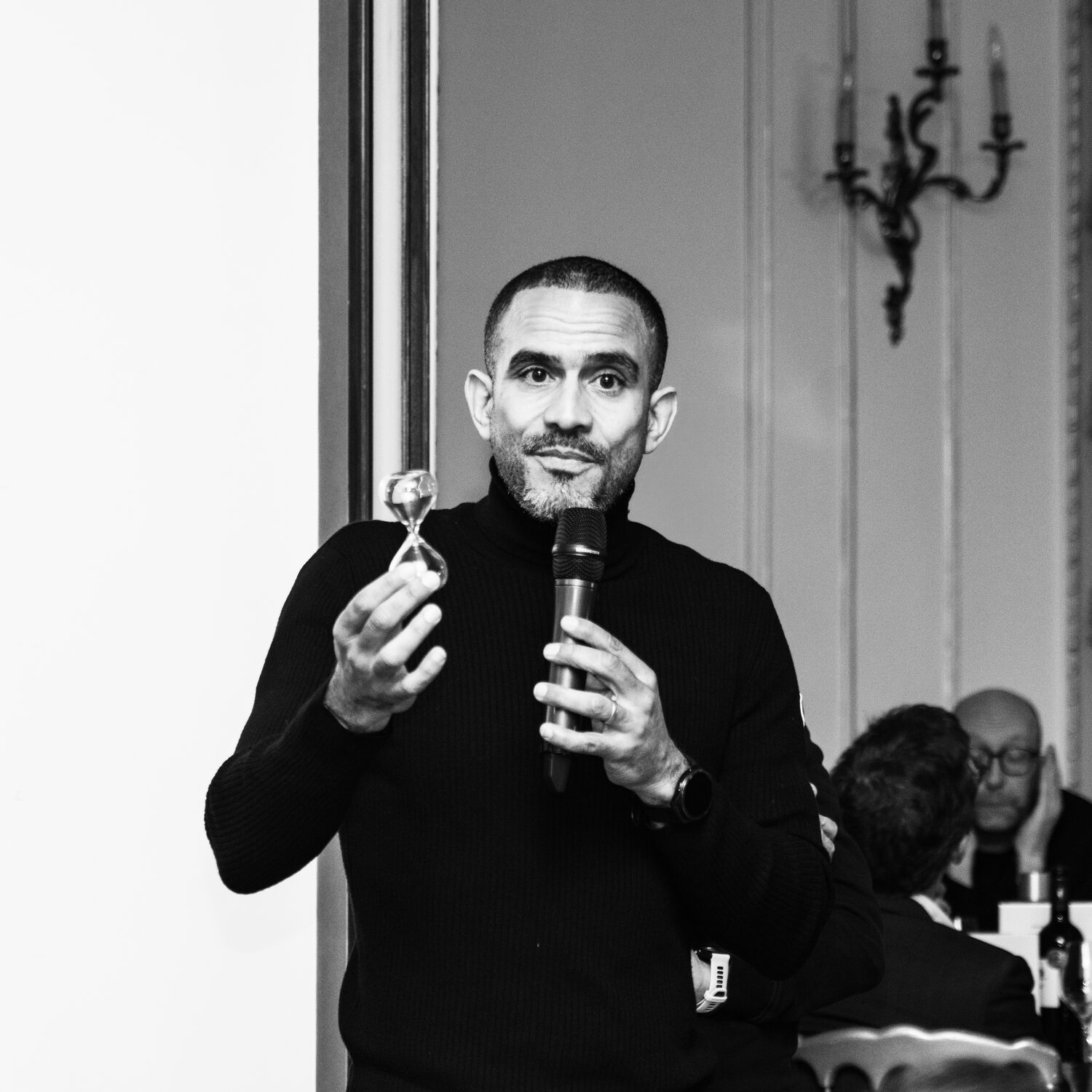 Un sablier présenté au micro lors d’un dîner